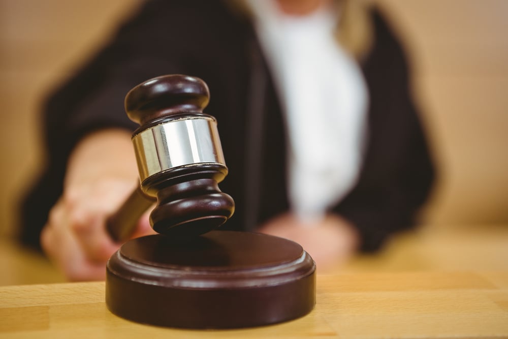Hand about to bang gavel on sounding block in the court room-1-1